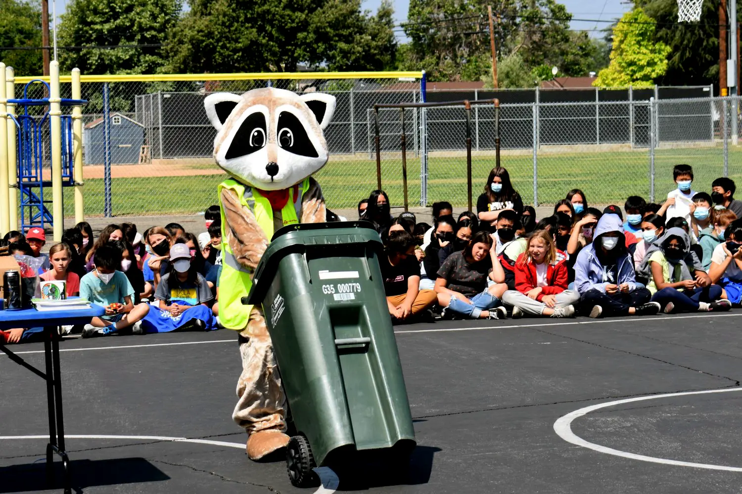 Rocky the Raccoon Pushing an Organics Recycling Bin infront of kids