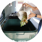 Throwing compostable food scraps onto green compost container